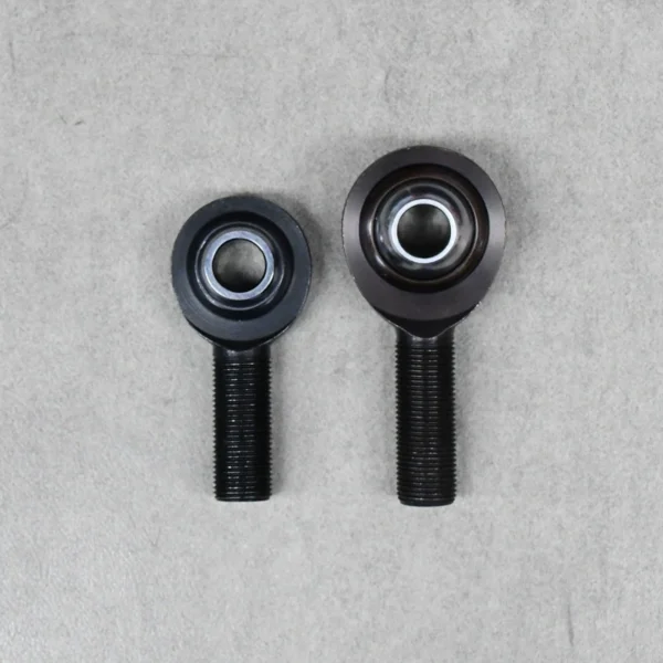 Front view of two black high-misalignment rod ends (PCM and PCYM), designed for suspension flexibility.