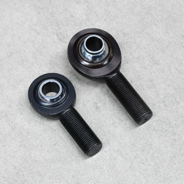 Two black high-misalignment rod ends (PCM and PCYM) designed for off-road suspension and steering systems.