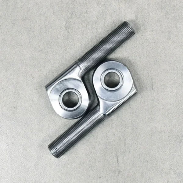 Two offset rod ends placed crosswise for suspension system adjustments.