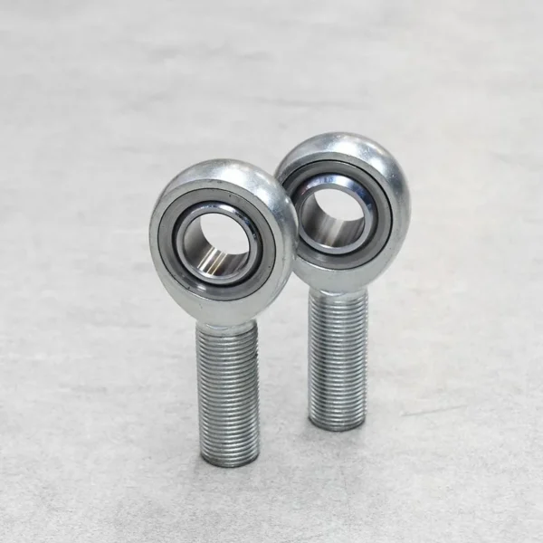 A pair of JMX male rod ends standing upright, designed for suspension and performance applications.