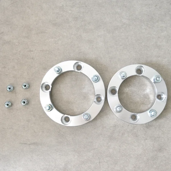 Two Polaris wheel spacers and nuts displayed, designed for off-road wheel modifications.