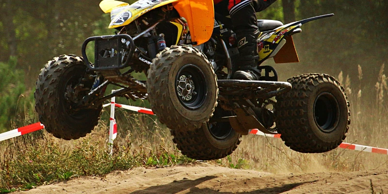 ATV jumping over a sand dune.