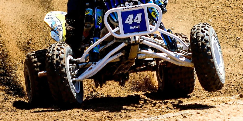 ATV making a sharp turn on rough terrain.