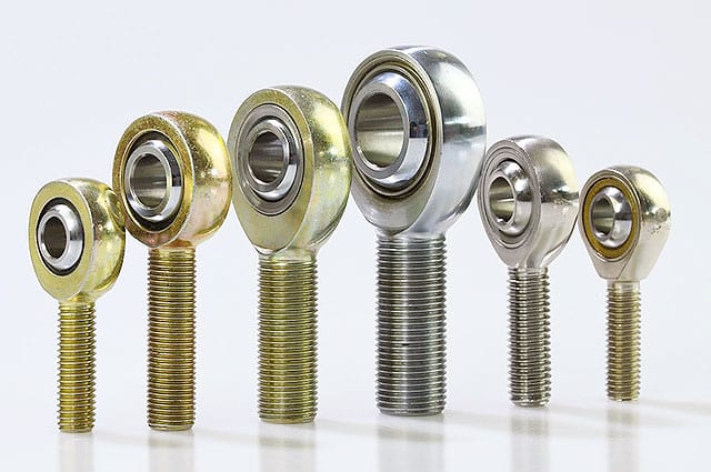 Assortment of metal rod end bearings with threaded shanks in various sizes.