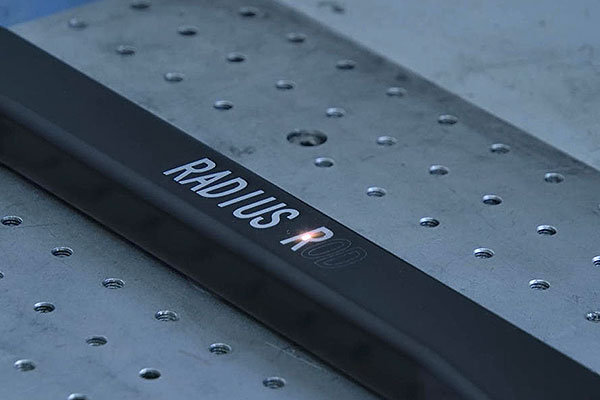 Close-up of a metal stair tread with a black anti-slip strip reading 'READ US'.