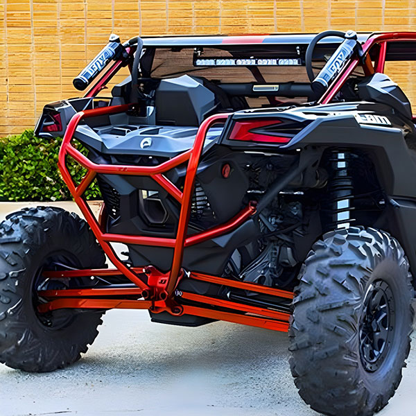 Orange roll-cage off-road buggy with large knobby tires parked outdoors.