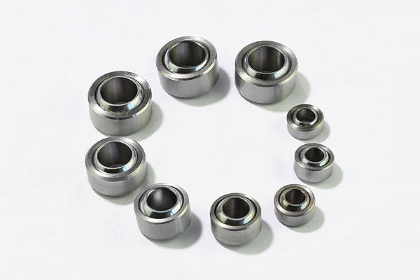 Set of metal ball bearings of various sizes arranged in a circle on a white background.
